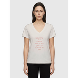 Woman wearing off white V-neck affirmation T-shirt with text You May Not Survive Whole But You Do Survive In Part, Le Van Kamp Studio